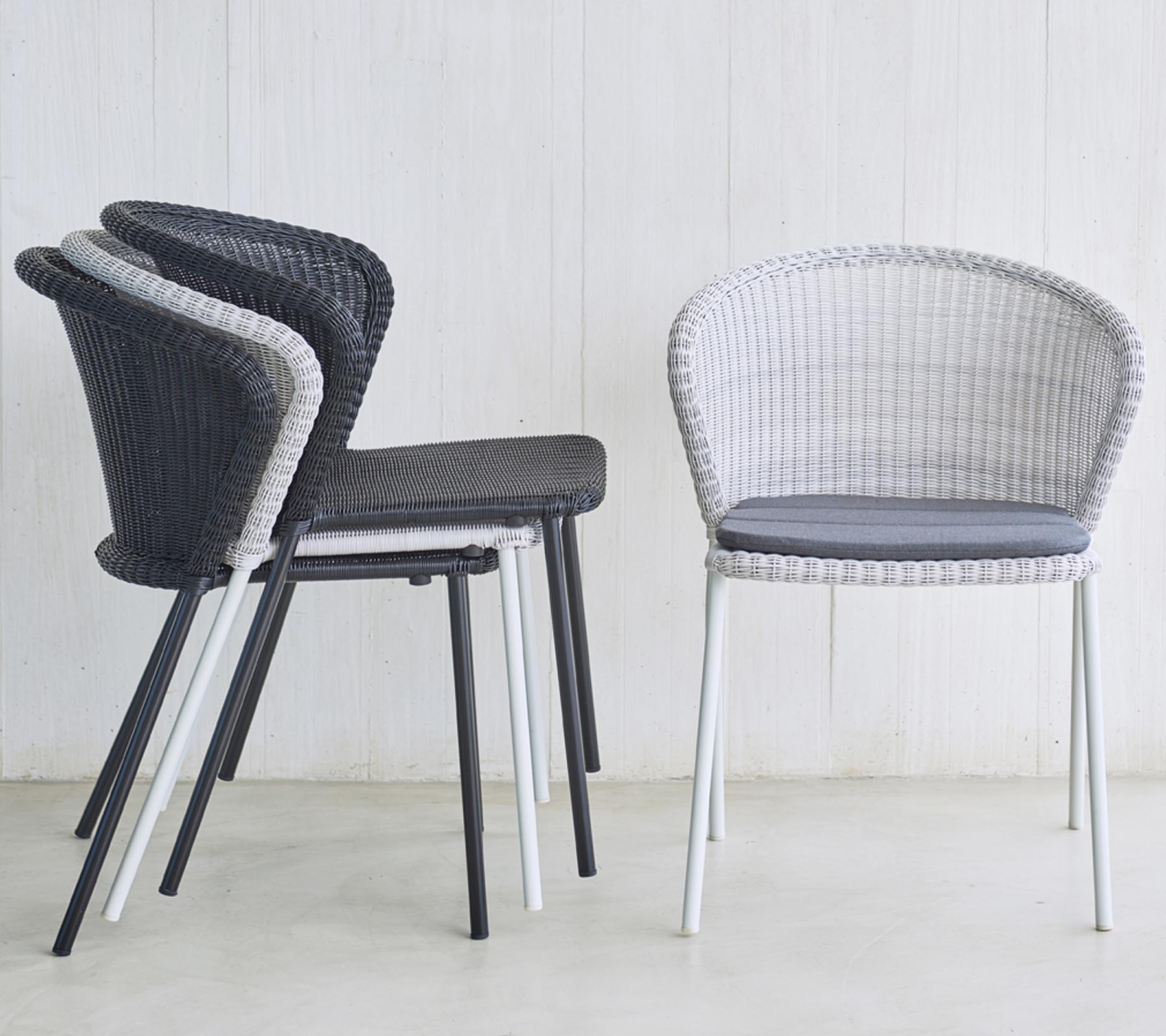 Hög med moderna, vävda stolar i svart och vitt, med stoppad sits, perfekt för stiliga sittlösningar.