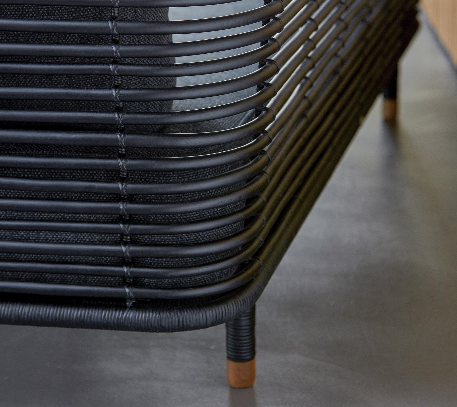 Stilfulla svarta vävda möbler med böljande linjer och trädetaljer, som visar en modern designestetik. En perfekt tillägg till vilket utrymme som helst.