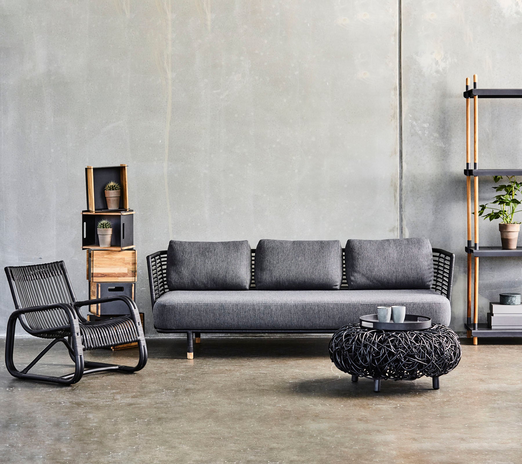 Modern vardagsrum med en stilren soffa, ett texturerat soffbord och en snygg accentstol, kompletterat med dekorativa hyllor.