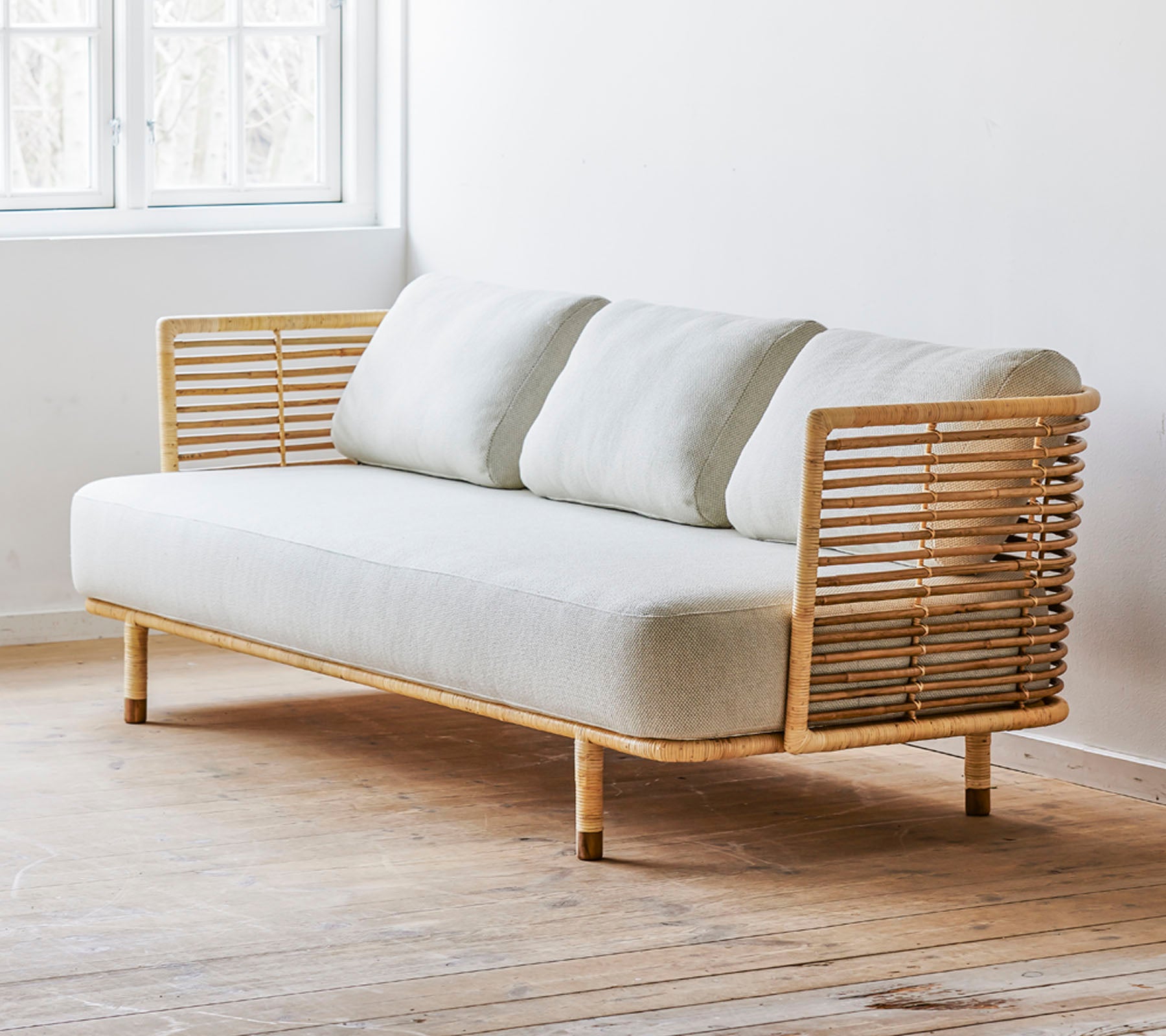 En modern soffa med en slank design och en ljus tygsits samt stiliga trädetaljer. Perfekt för moderna miljöer.
