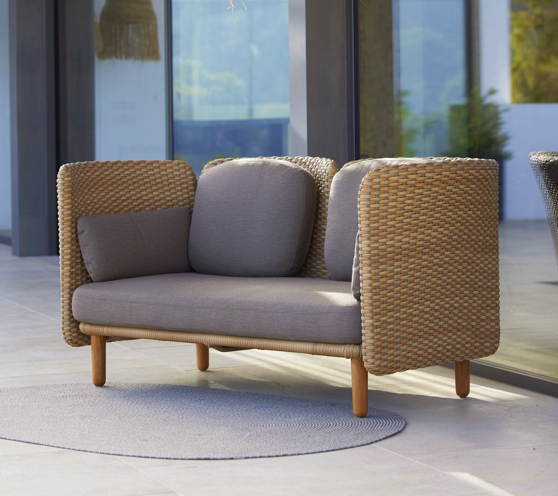 Arch 2-sitssoffa med låg ryggstöd, vävda sidor och neutrala kuddar som förenar komfort med modern design.