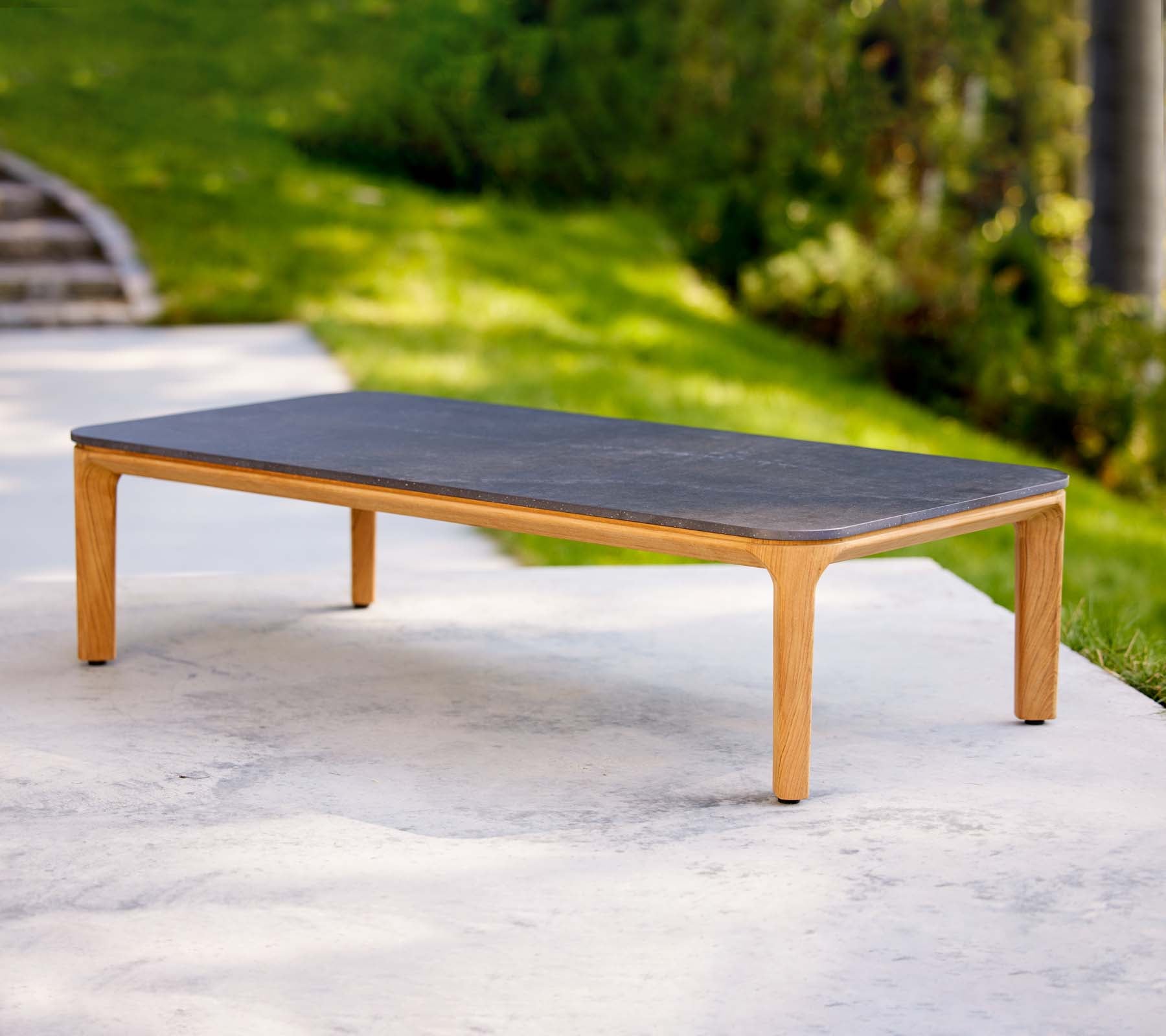 Ett stilrent coffeetable med en mörk yta och ljusa träben, perfekt för moderna vardagsrum.