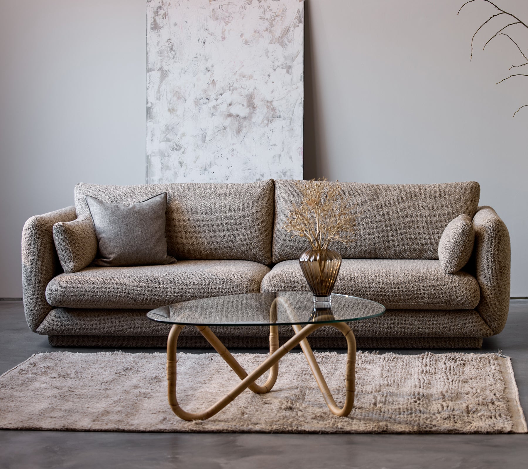 Bloom 3-sits soffa i taupe flair med sockel, tillsammans med ett Wave inomhus soffbord och en dekorativ vas, på en mjuk matta.