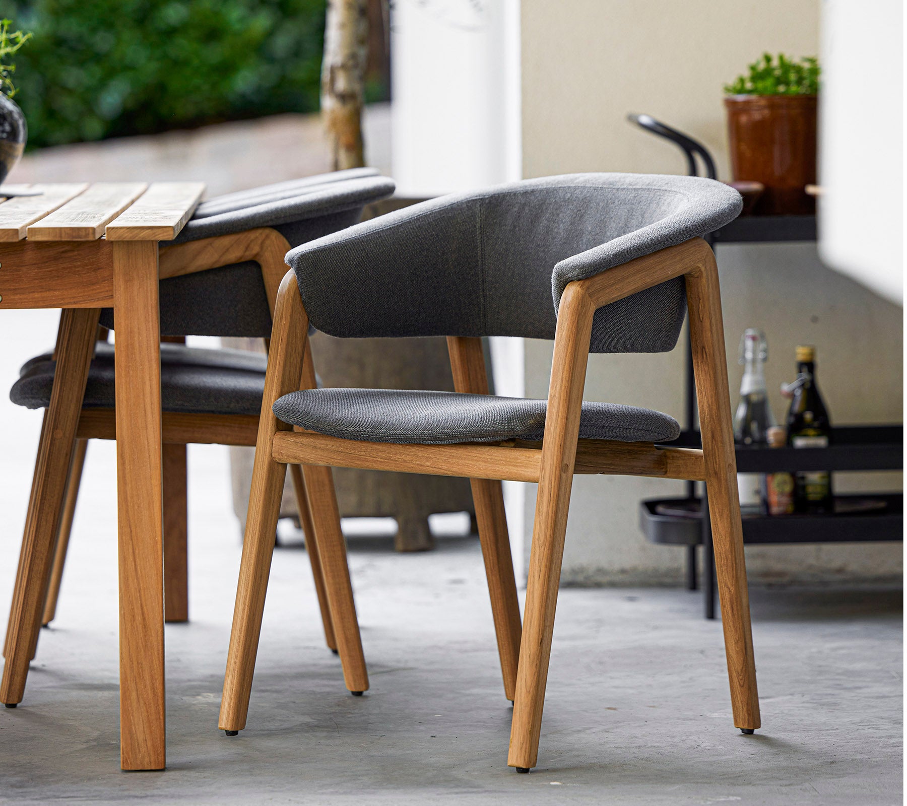 Stilren stol med trästomme och grå klädsel, designad för komfort och elegans, perfekt för moderna miljöer.