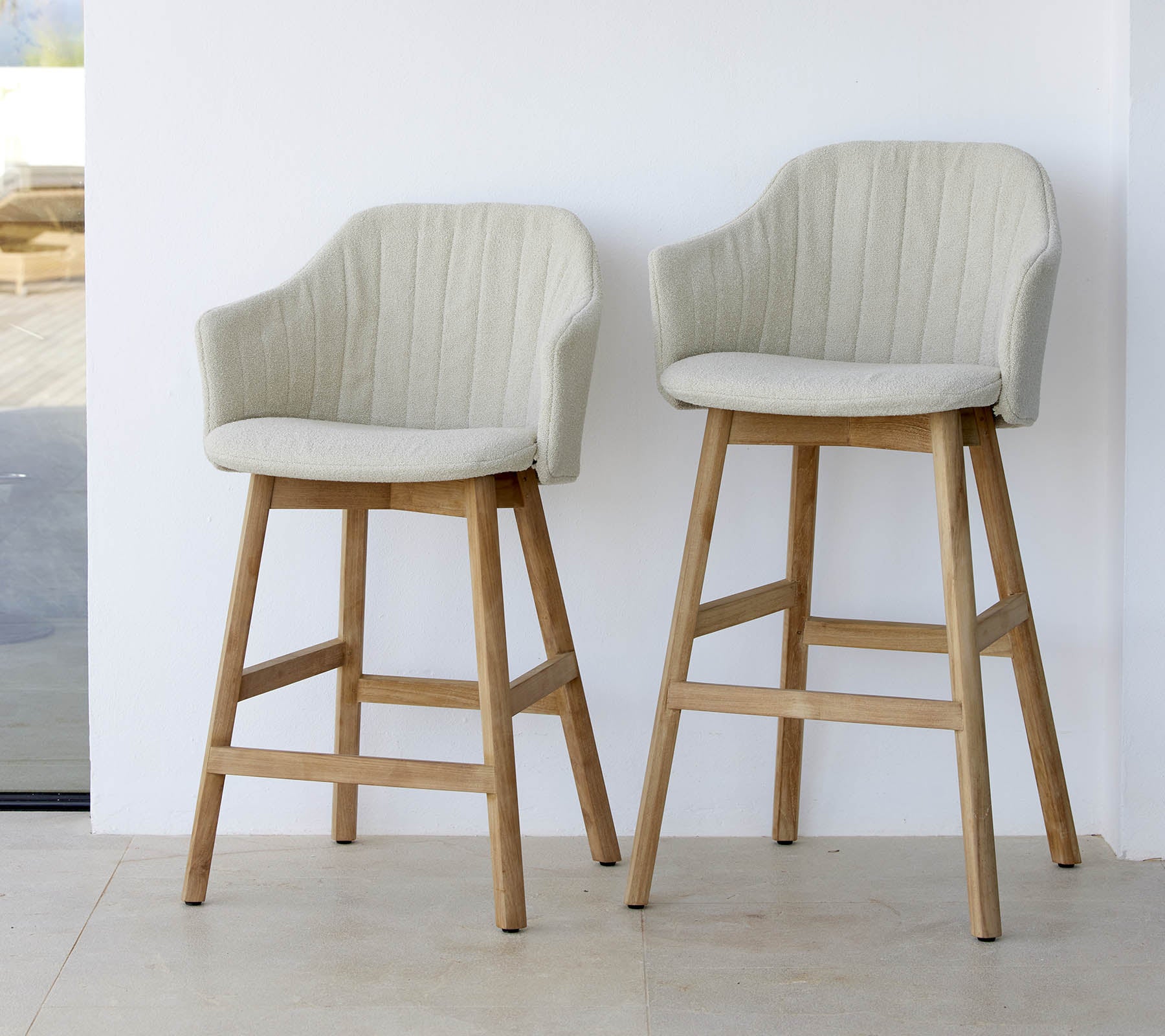 Två stiliga, ljusa stolar med böjda ryggar och träben som visar en modern och bekväm design.