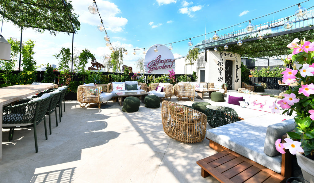 Grace Garden rooftop terrace with bar and lounge. Many lounge chairs in both rectangular and round in natural material, dark green dining chair 