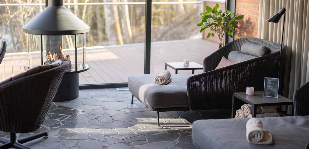 Hestraviken Spa furnished with Cane-line furniture in their lounge area. Mega daybed black and Peacock lounge chair grey with swivel base in aluminium