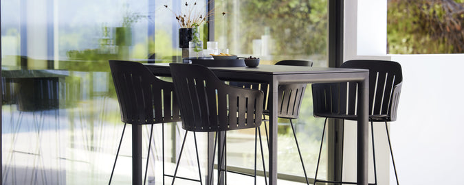 Modern bardisk med matchande barstolar, med en stilren design och minimalistisk estetik, perfekt för sociala tillställningar och avslappning.