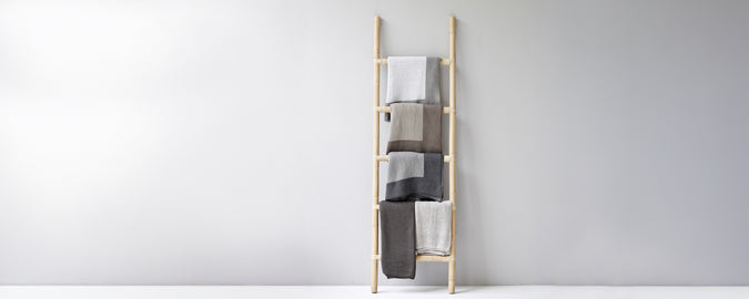 Moderna handduksstege som visar beige, grå och vita handdukar.