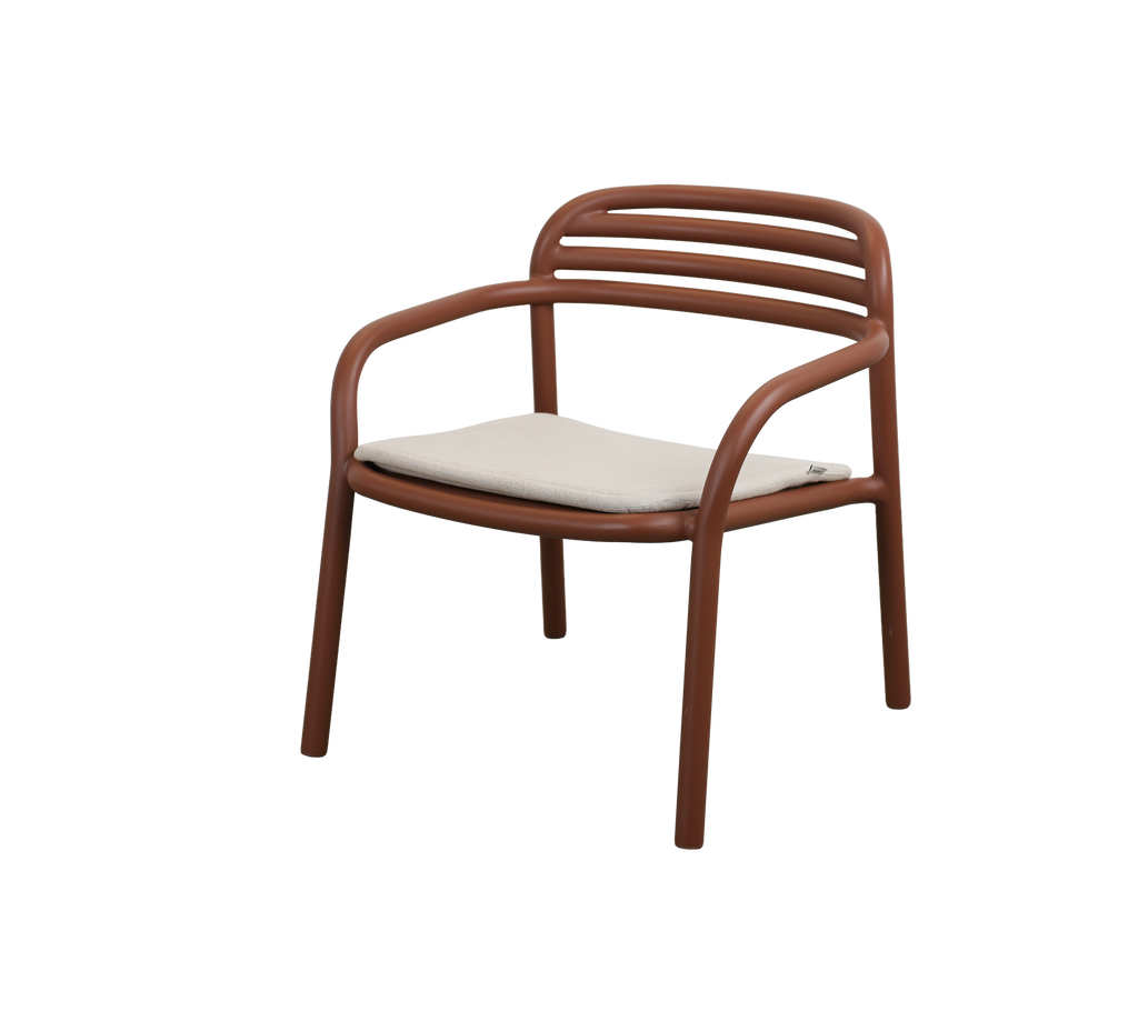 Modern ökenröd stol med en sandkudde.