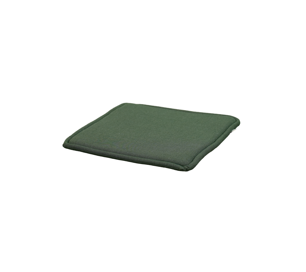 Ljusgrön kudde placerad på en platt yta.