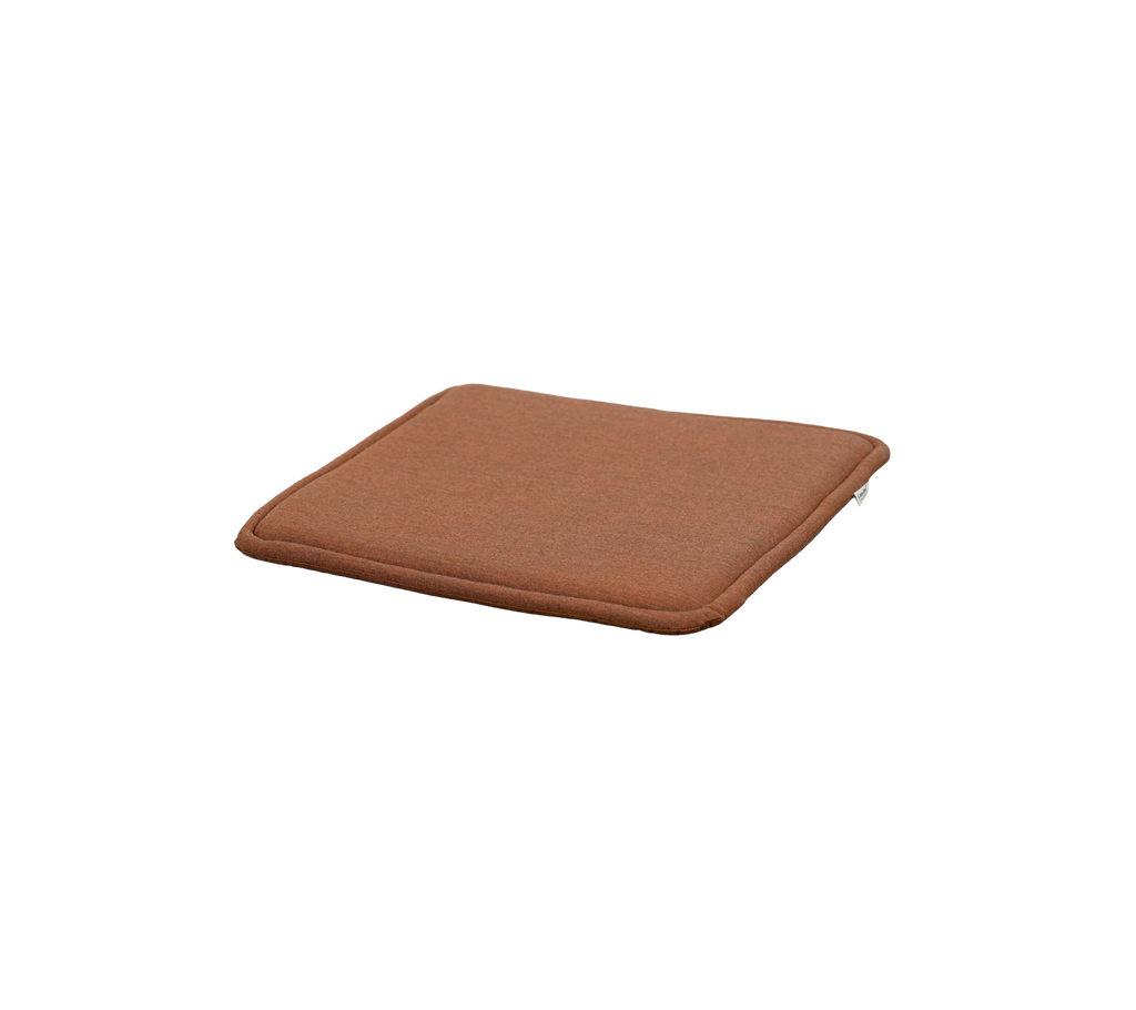 ökenröd kudde med fyrkantig form och subtil tjocklek.