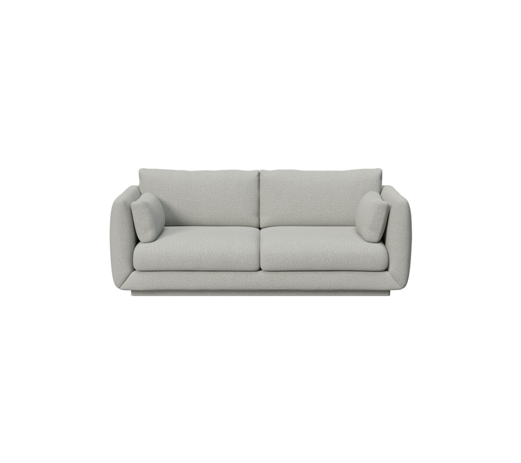 Ljusgrå soffa med minimalistisk design och rundade kuddar.