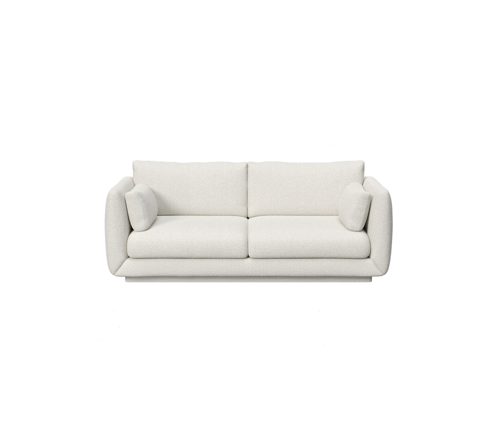 Vit modern minimalistisk soffa med rundade armstöd och plyschkuddar.