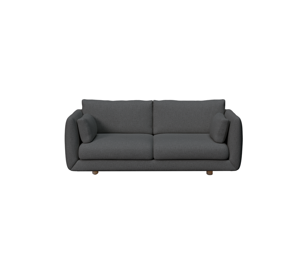 Mörkgrön soffa med två kuddar i en modern loungemiljö.