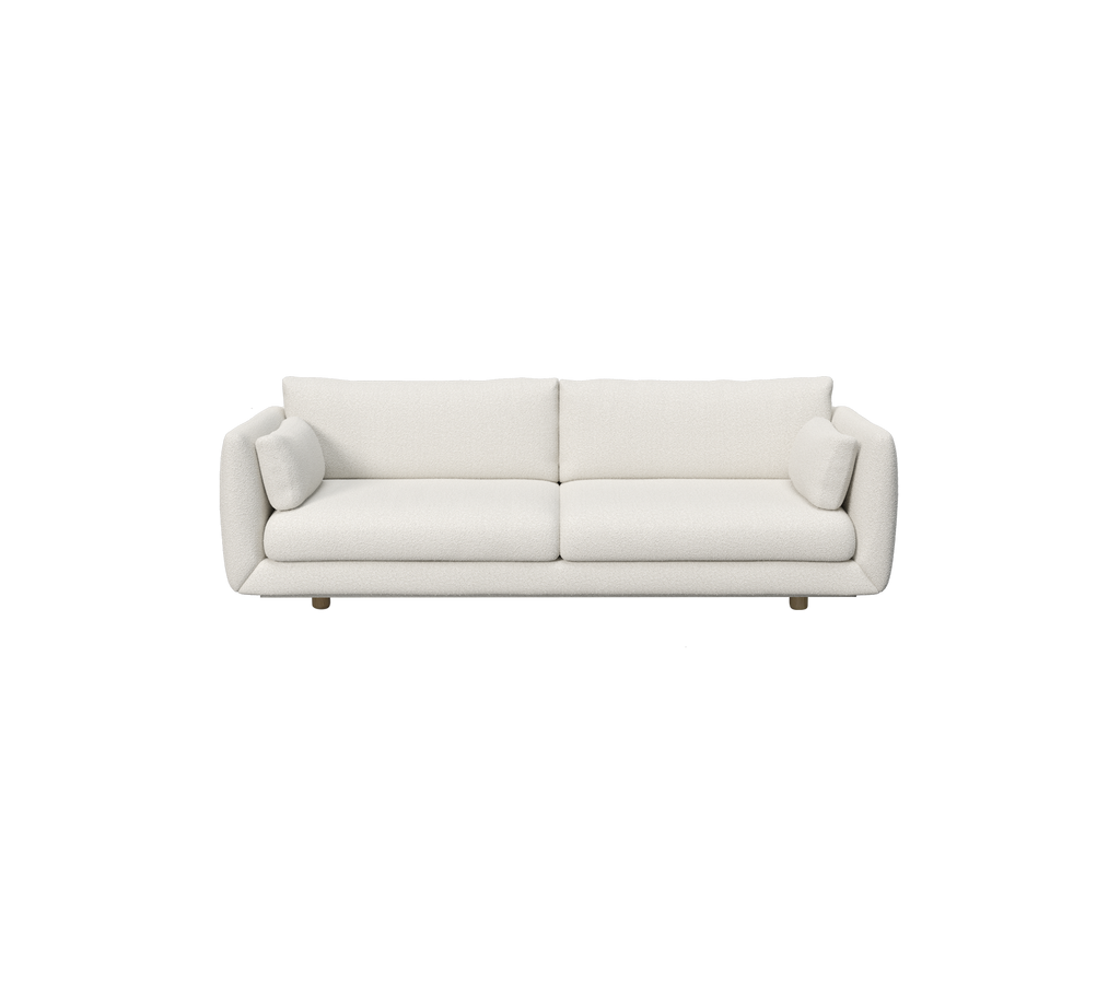 Modern vit soffa med cylindriska kuddar.