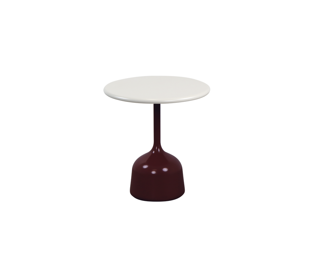 Modernt burgunderfärgat bord med en vit bordsskiva i en lounge-setting.