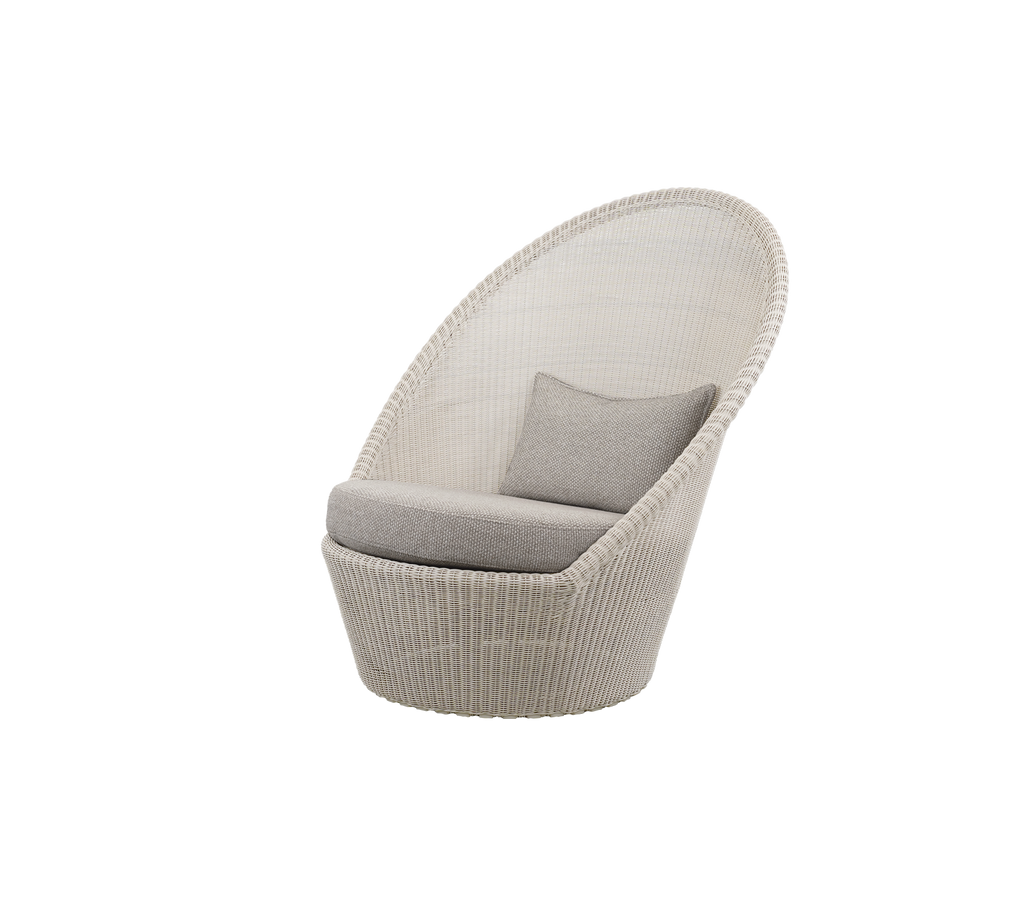 Ljusbrun stol med sandfärgad kudde i en modern lounge-miljö.