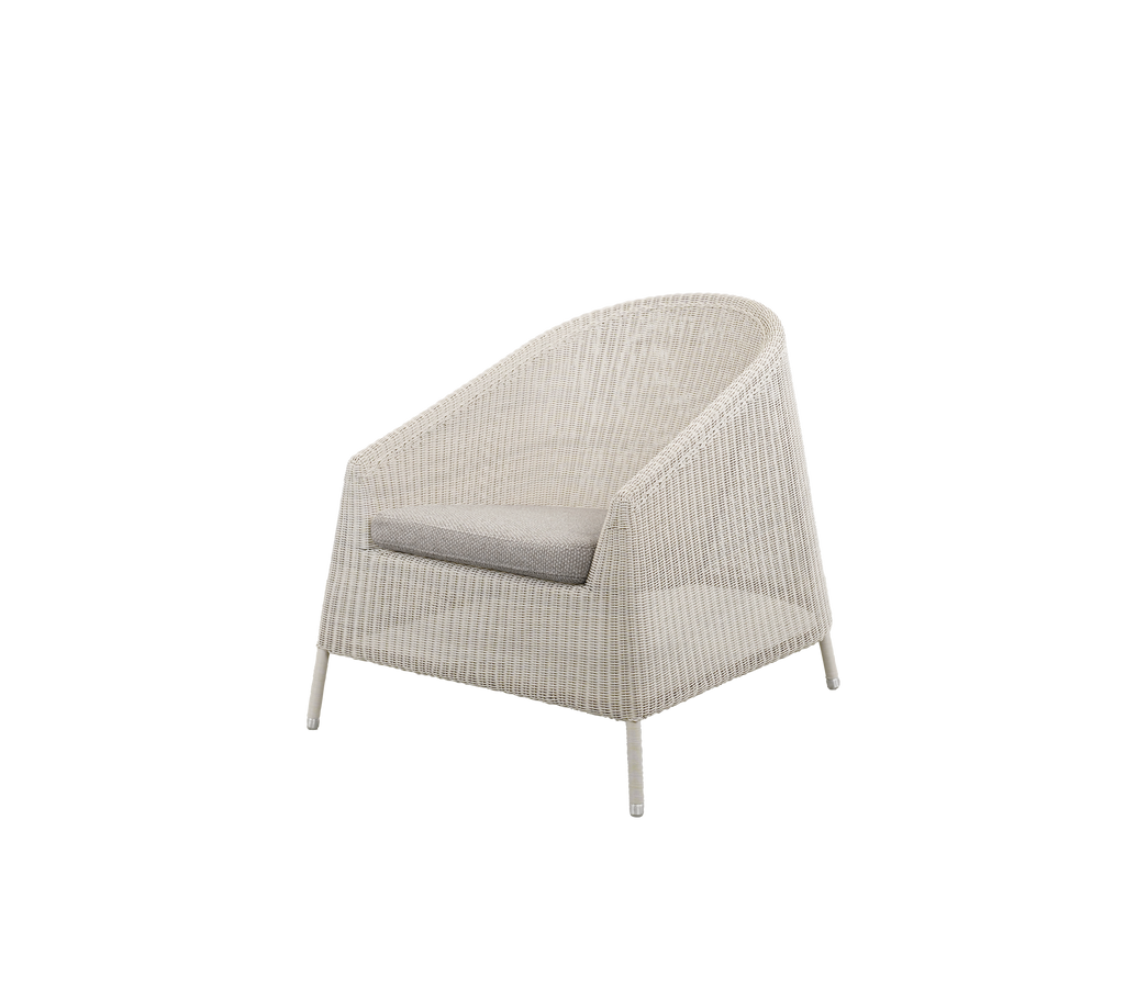 Modern stol med ett ljusbrunt kudde i en mysig miljö.