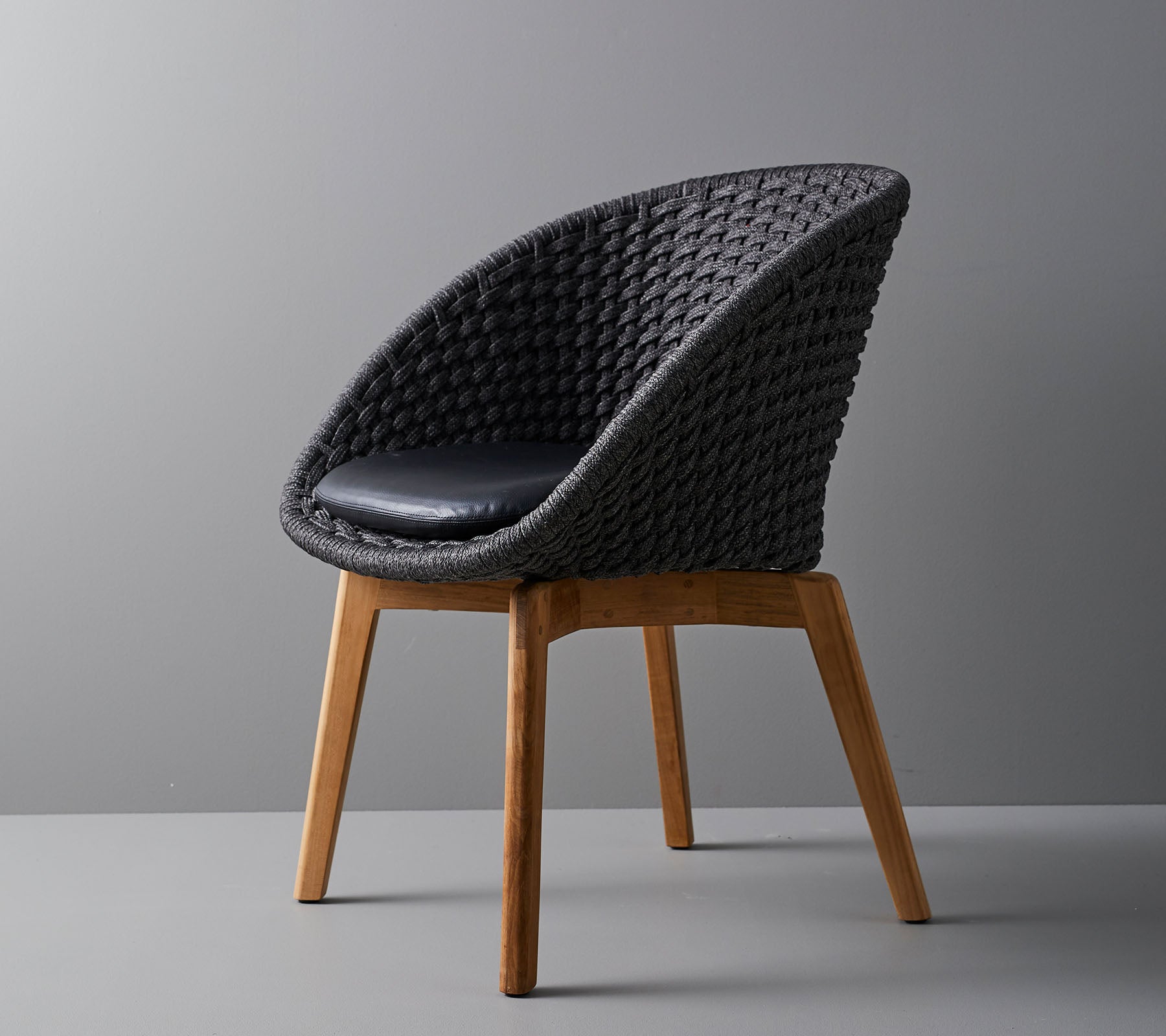 Stilfull vävd stol med en bekväm dyna, med släta, avsmalnande träben och en modern design som passar i olika miljöer.