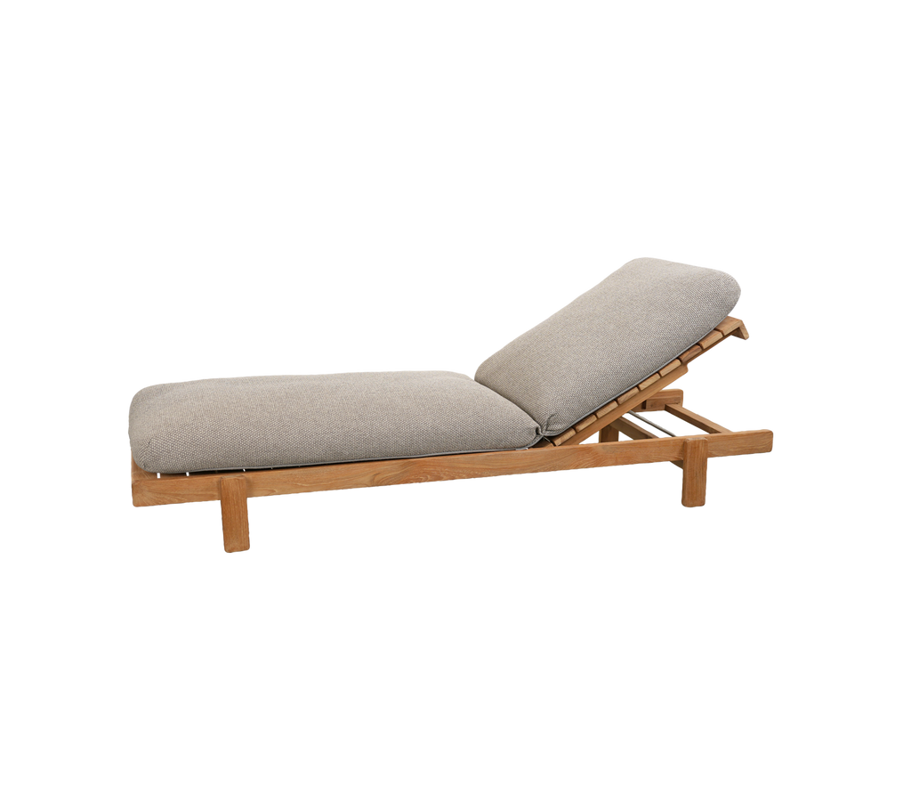 Ljusbrun soffa med en grå kudde och justerbart ryggstöd.