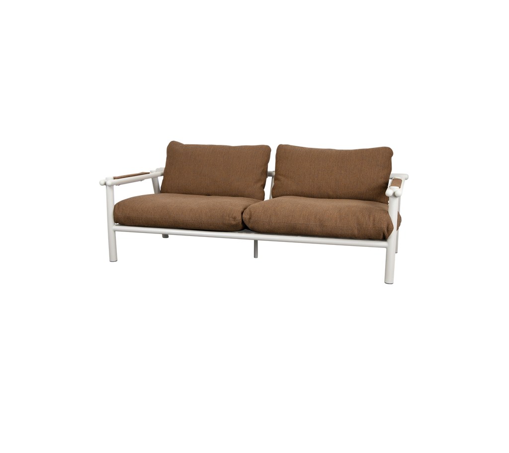 Modern lounge-soffa med umbrabrown kuddar och ljus ram.