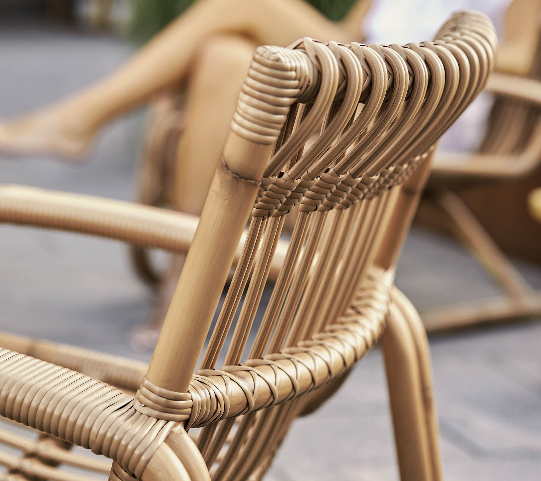 Närupplevelse av en stilren vävd stol med modern design, som visar detaljerat hantverk och naturliga material.