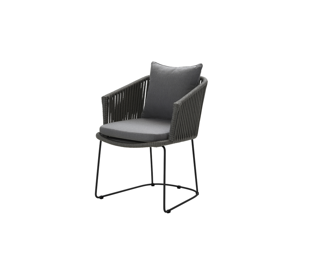 Stilren fåtölj med ett grått kuddfodral, ett vävt ryggstöd och en stilren svart metallram. Perfekt för modern inredning.
