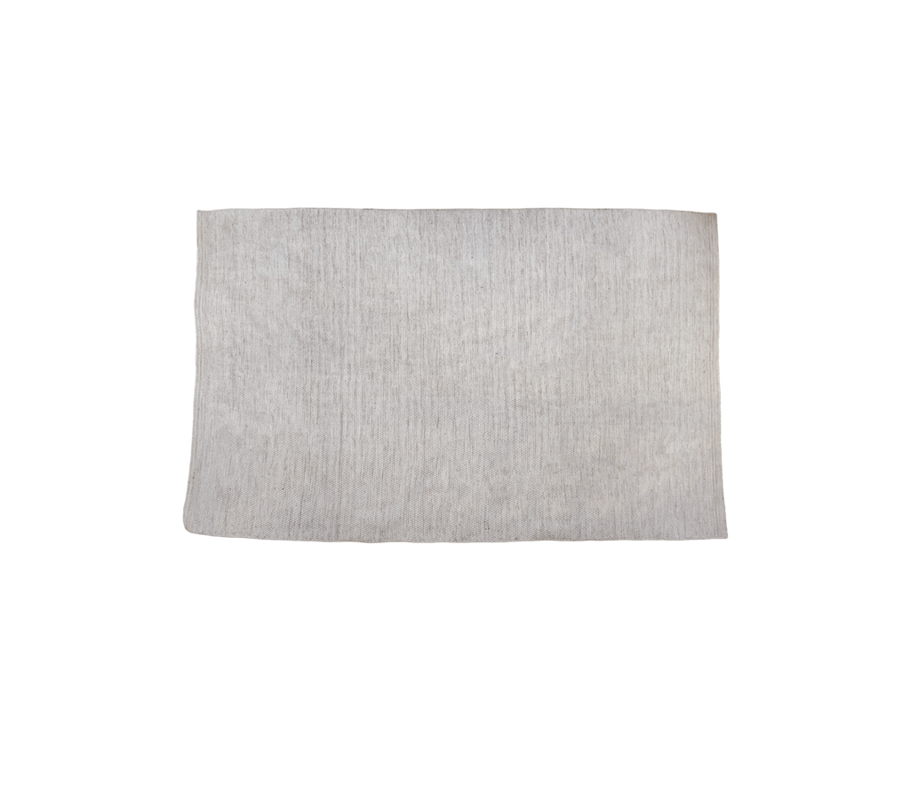 Flerfärgad matta i en sandton med texturerad yta.