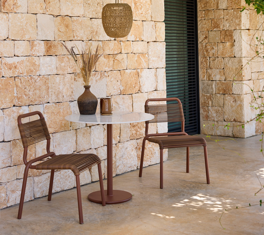 Modern loungeuppställning med bruna stolar och ett vitt bord.