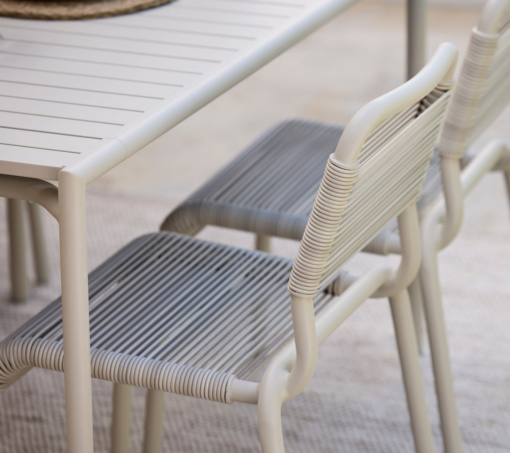 Modernt matbord med vit finish och grå stolar.