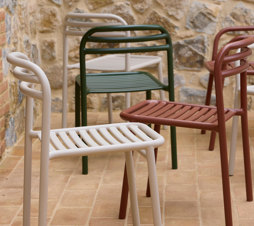 Bliss chairs displayed in various colors, featuring a modern design with slatted seating and curved arms.