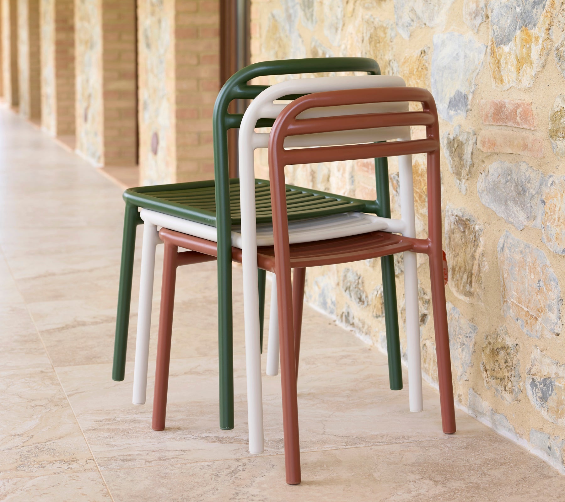 En stapel Bliss-stolar i olika färger, som visar elegant design och praktisk platsbesparande förvaring.