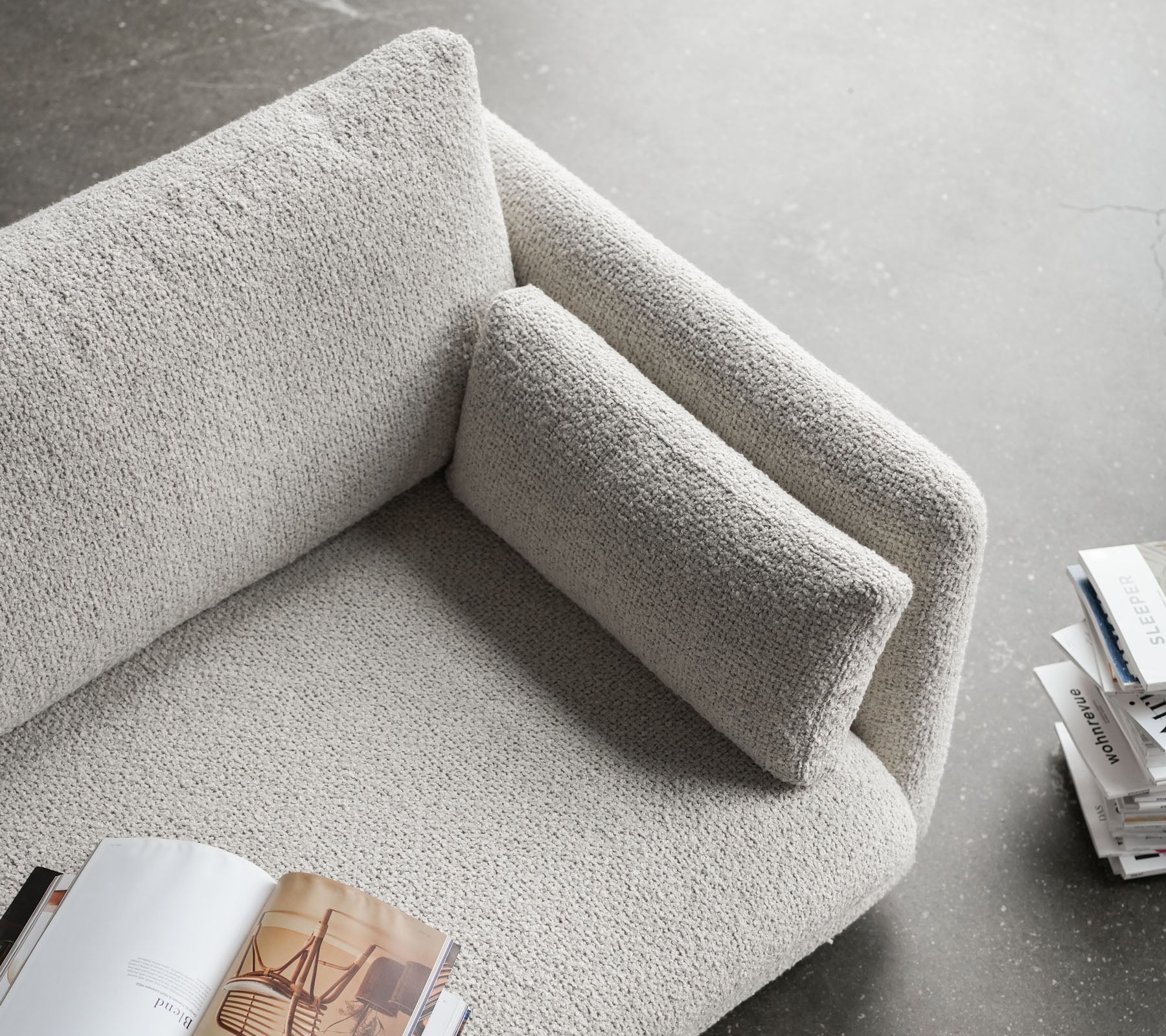 Stilig soffa med en texturerad yta, som har ett mjukt armstöd och en bekväm kudde, perfekt för avkoppling och läsning.