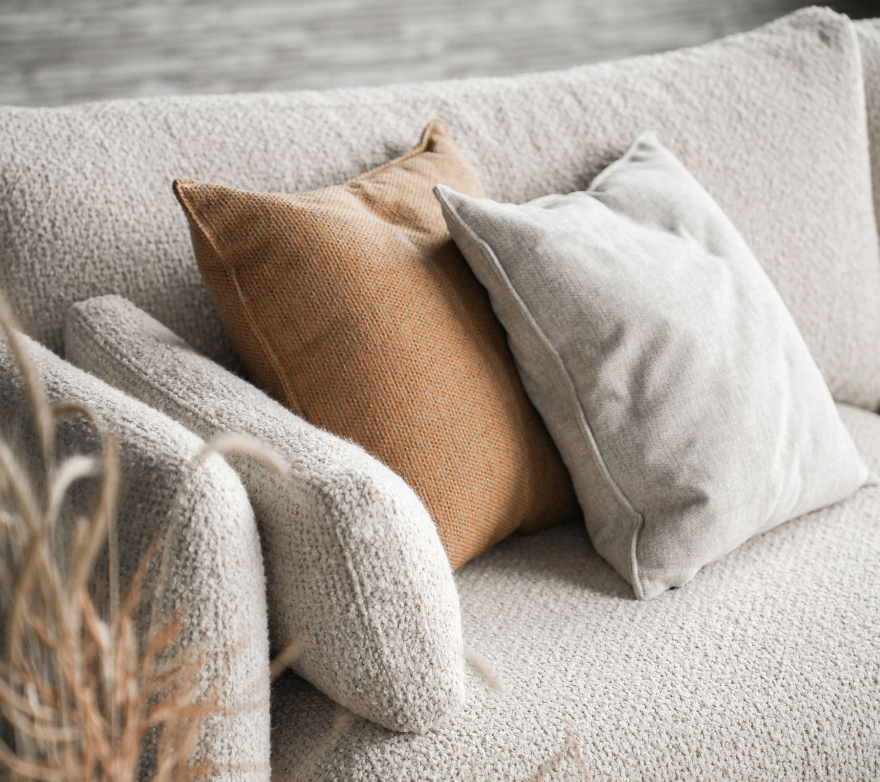 Mysig soffa med Bloom i sandfärg med två kuddar, en i beige och den andra i varm brunt, vilket ger en stilig touch.
