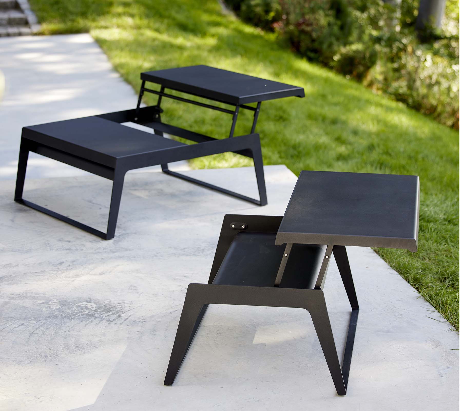 Två moderna chill-out soffbord med eleganta designer och minimalistiska svarta ytor som visar mångsidighet i stil och funktionalitet.