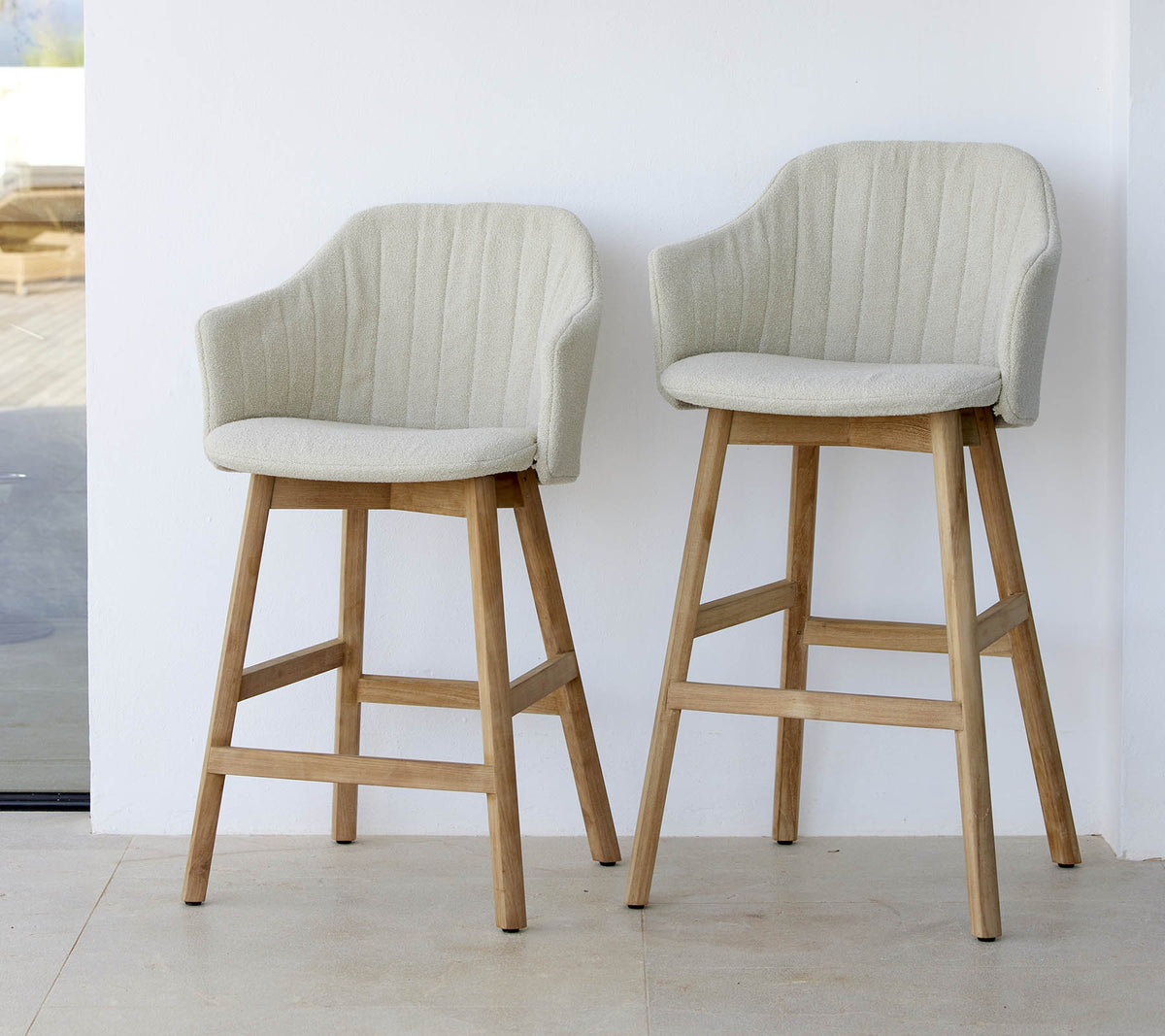 Två stiliga, ljusa stolar med böjda ryggar och träben som visar en modern och bekväm design.