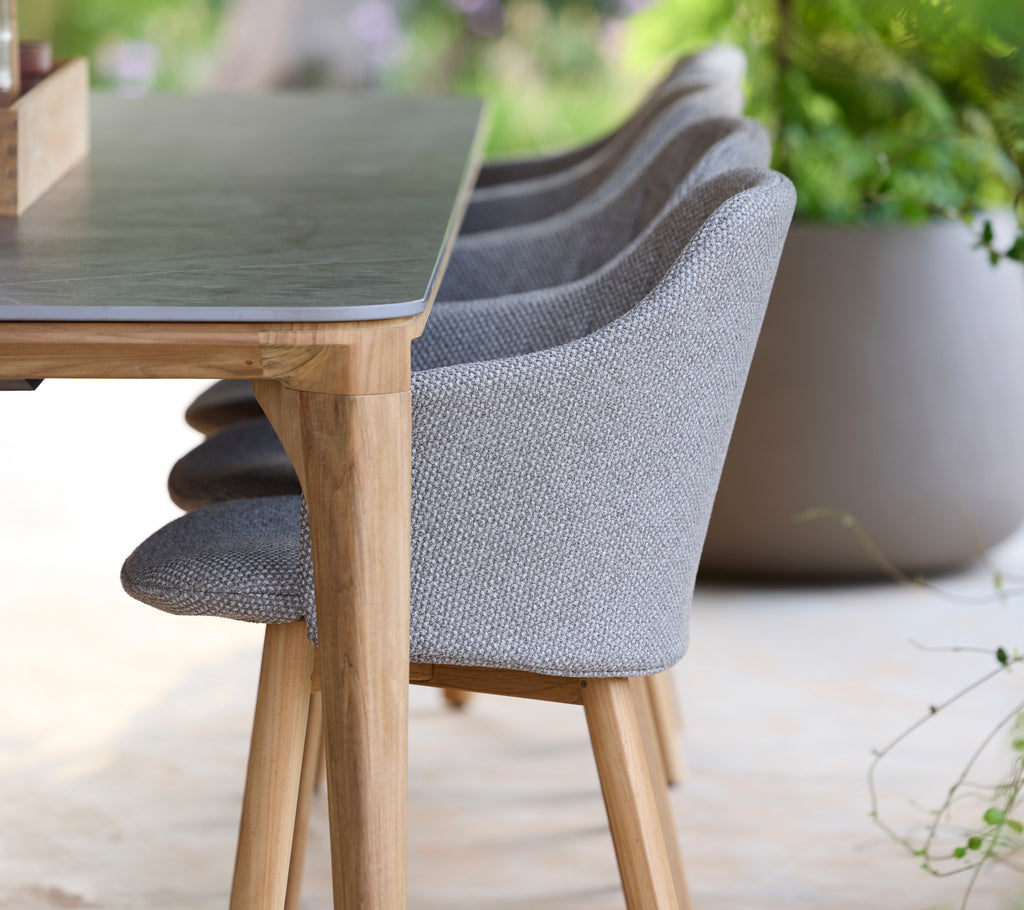 Modern grå stol och bord i en lugn utomhusmiljö.