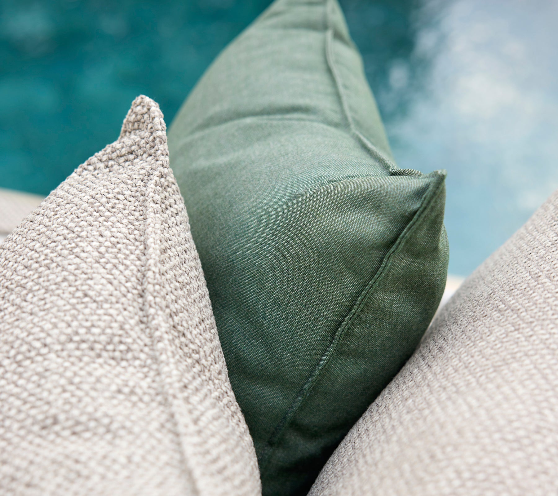 Gröna och grå kuddar arrangerade tillsammans.