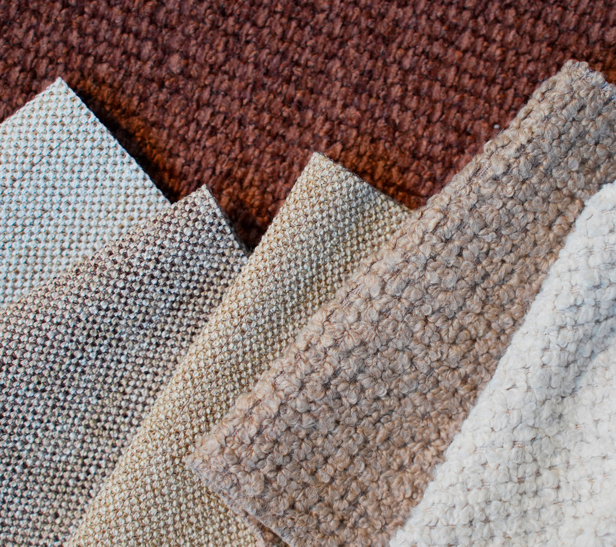 Prover av olika texturerade tyger i brunt, beige, ljusgrått och vitt.