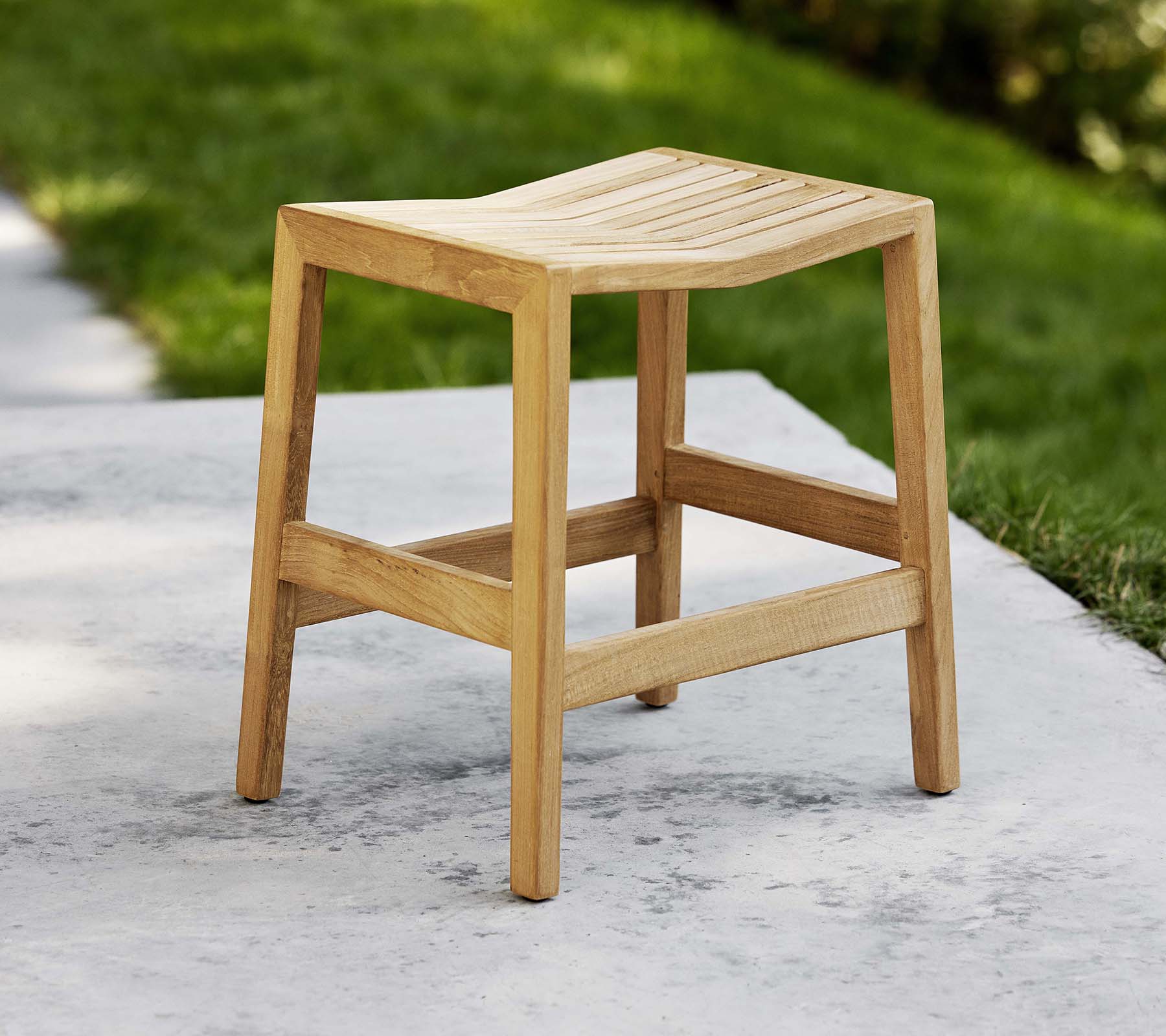 En träfällstol med ribbad sits och stadiga ben, designad för mångsidig användning som sittplats eller dekor.