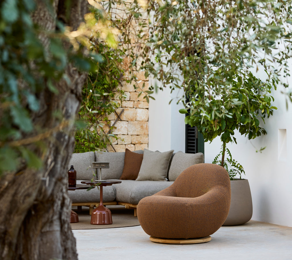 Modern loungeområde med en brun stol och en grå sektionsoffa.