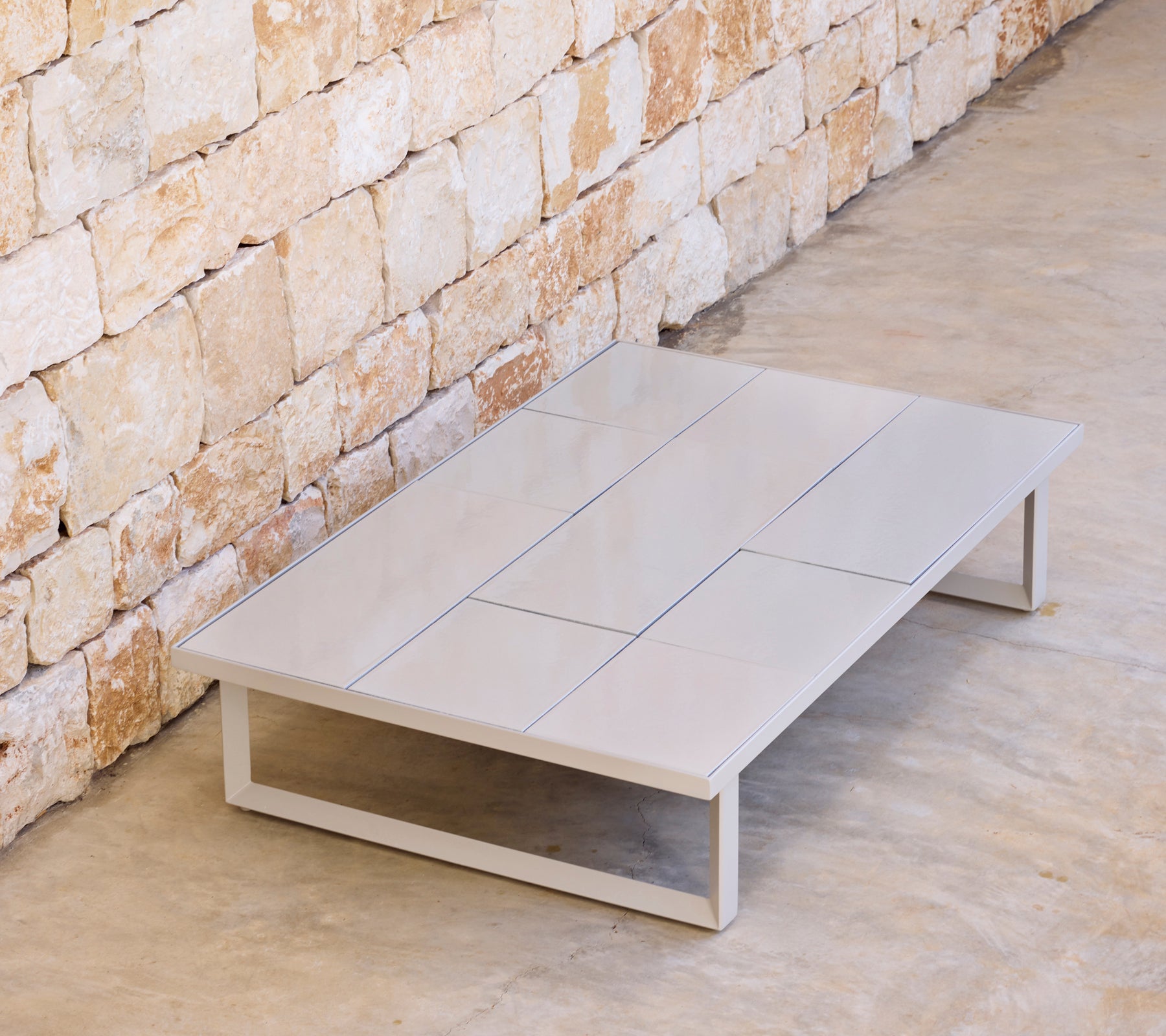Modernt grått soffbord med en minimalistisk design i en naturlig miljö.