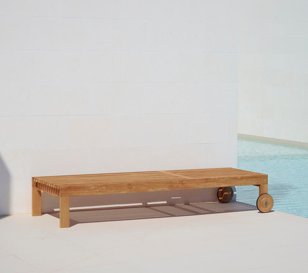 Träsolstol med minimalistisk design, med en slät yta och ett hjul för lätt rörlighet. Perfekt för avkoppling vid poolen.