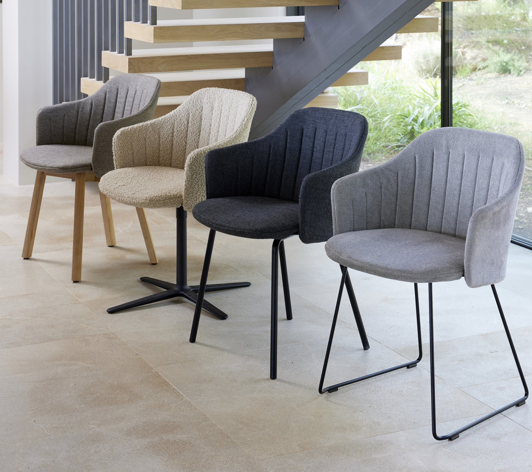 Fyra moderna stolar i olika färger och stilar som visas i en samtida miljö och visar sina unika designer.