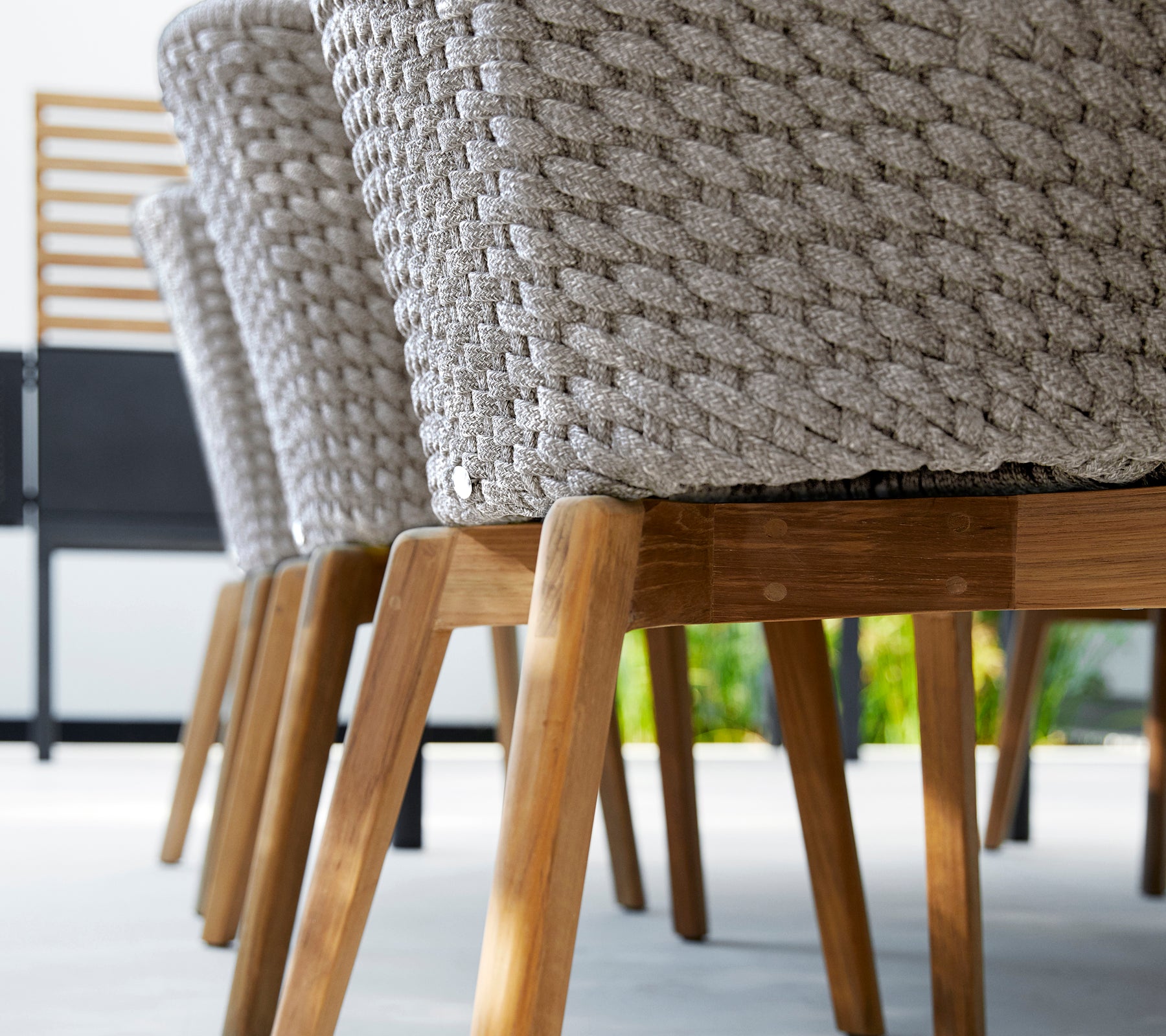 Modern grå stol med en vävd design och träben.