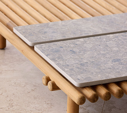 En träplattform har två stentoppar som framhäver en modern design med naturliga element för en stilren presentation.