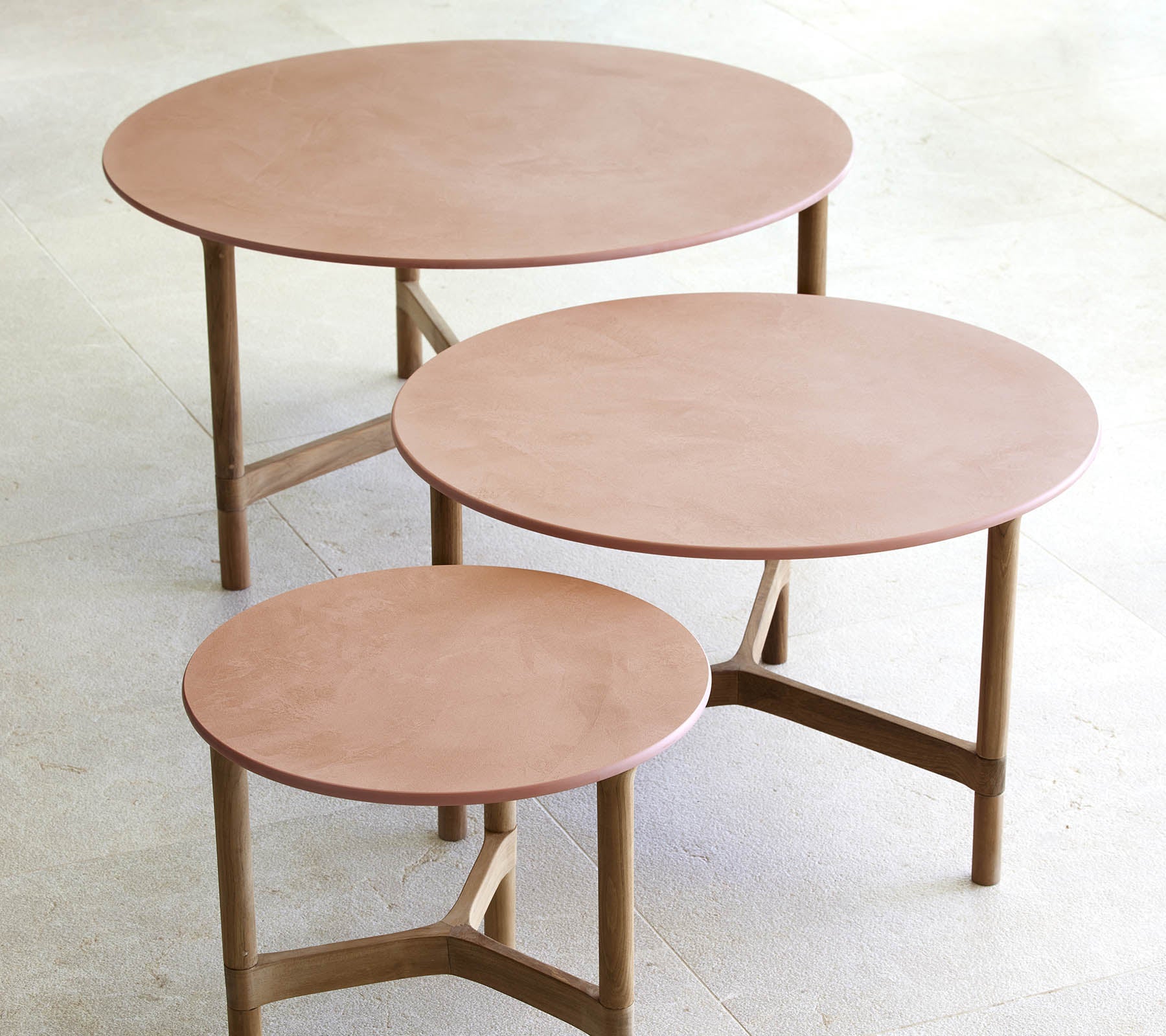 Tre runda soffbord i olika storlekar med en minimalistisk design, träben och en slät, elegant yta.