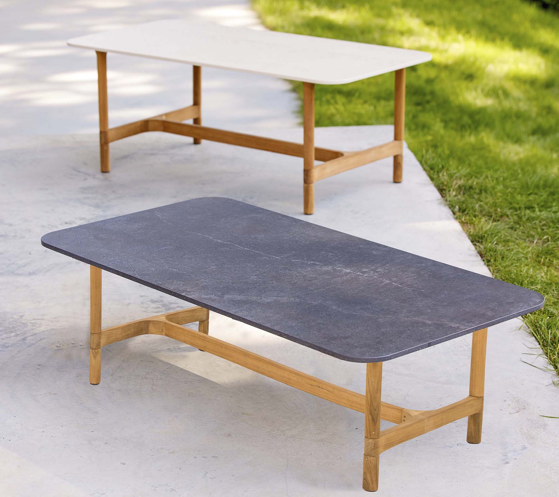 Två stiliga soffbord med träramar och kontrasterande bordsfärger, med en modern, minimalistisk design.