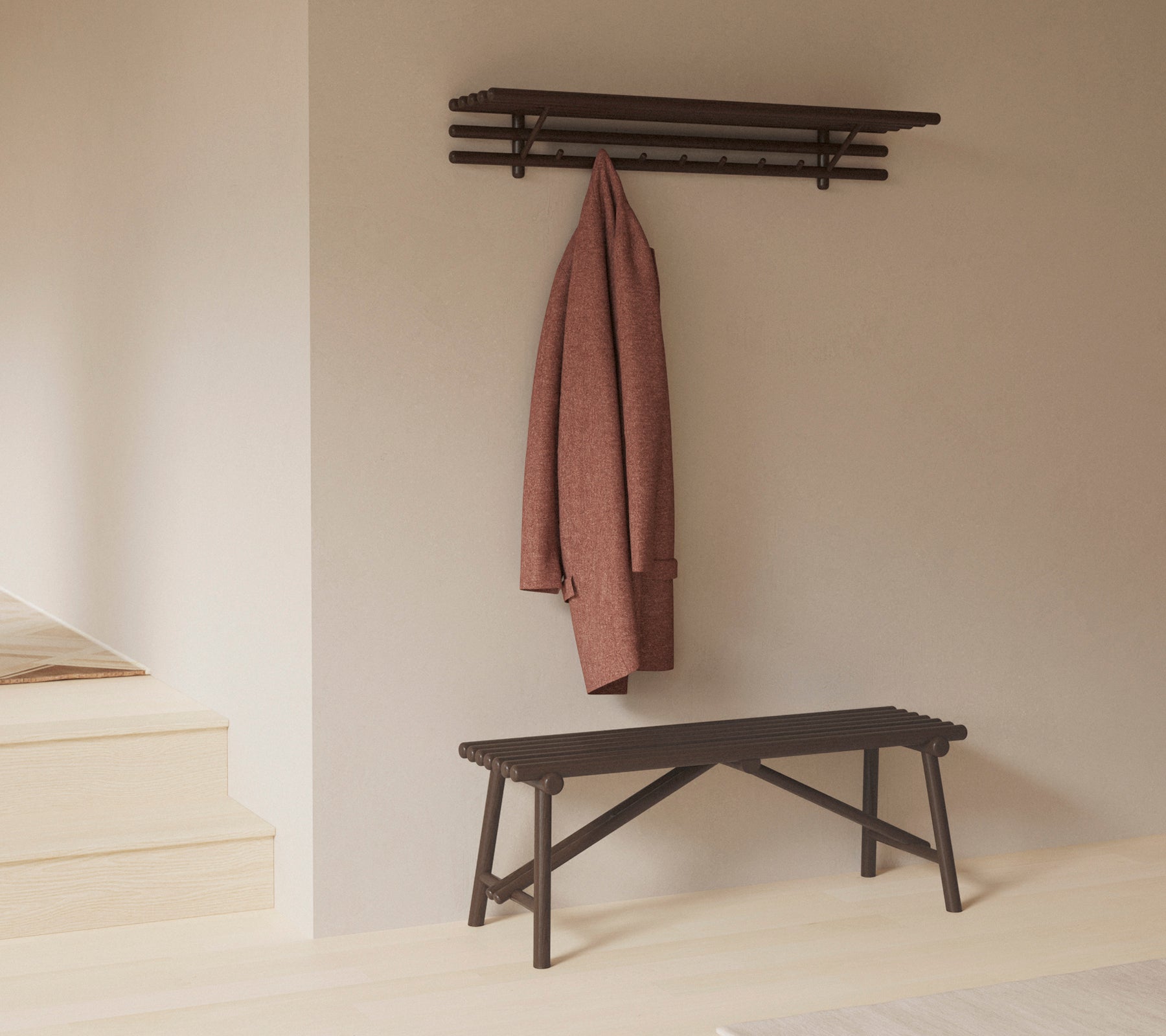En minimalistisk bänk med en hylla ovanför, som visar en kappa hängande på krokar, vilket betonar enkelhet och funktionalitet i designen.